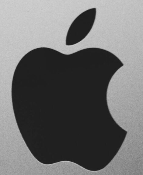 Close-up of a black and white Apple logo on a desktop screen with a modern minimalist design.